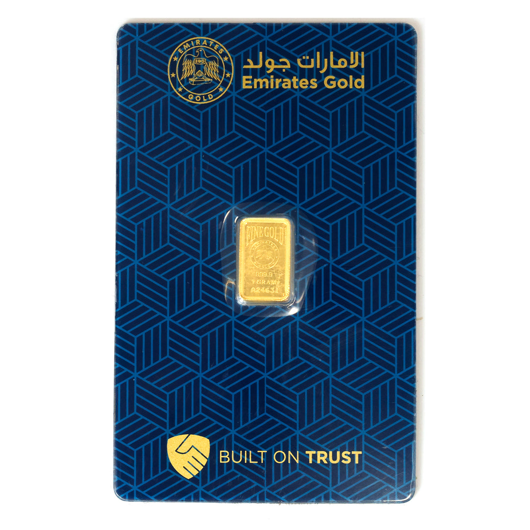 Gold bar on a blue Emirates Gold packaging with branding and text.