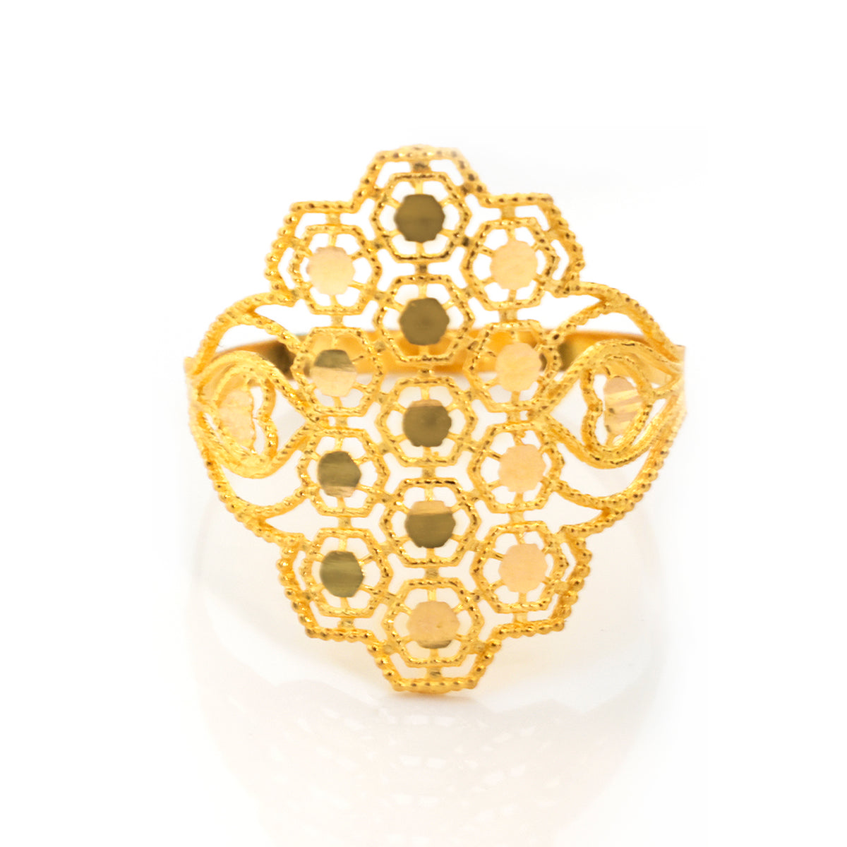A gold filigree ring with a geometric, honeycomb-like openwork design and circular cutouts, photographed on a clean white background with a soft reflection.
