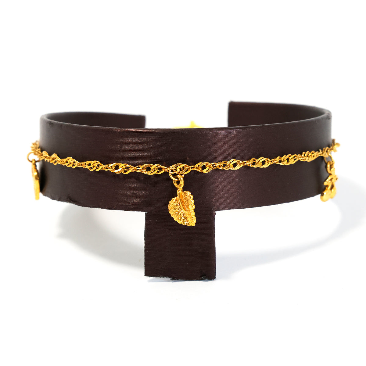 Brown leather choker with gold chain and charms on a white background