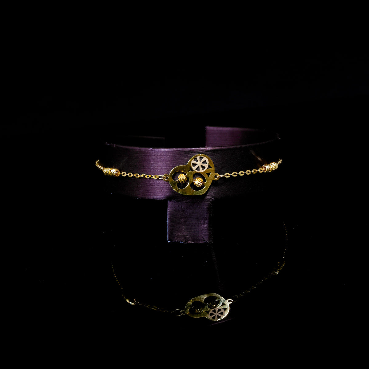 Purple choker with gold and silver decorative elements on a black background