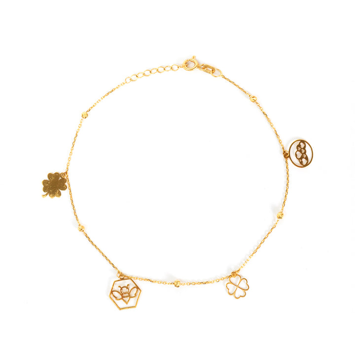 Gold bracelet with floral charms on a white background