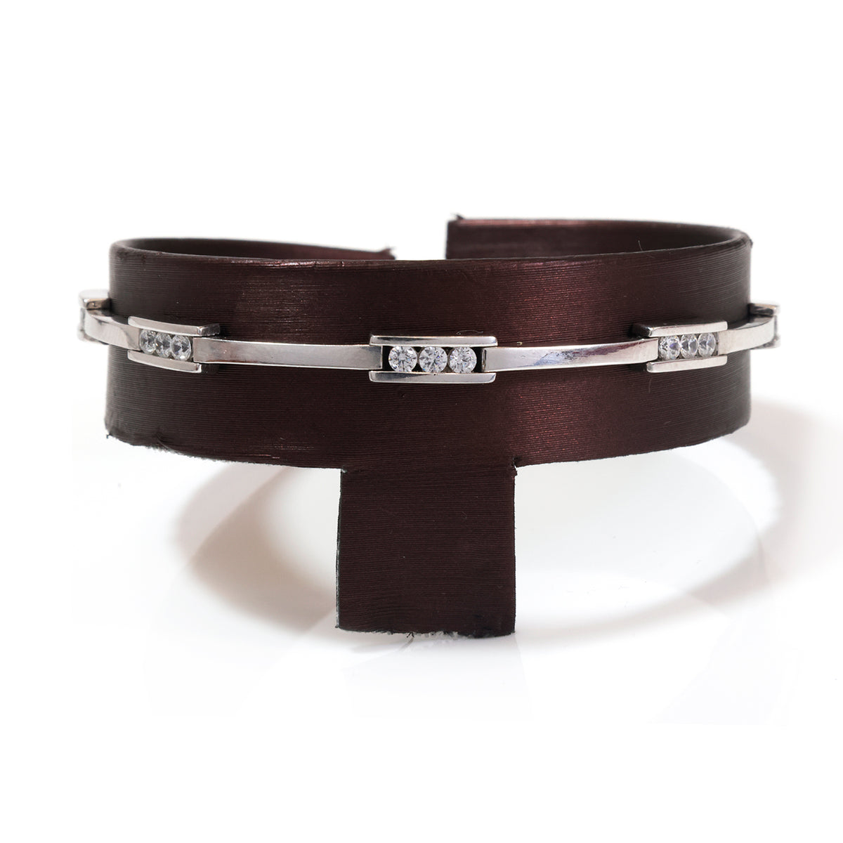 A dark brown wide cuff bracelet with a silver-toned metal band accented by three rectangular bezel-set diamond clusters, displayed on a white background.