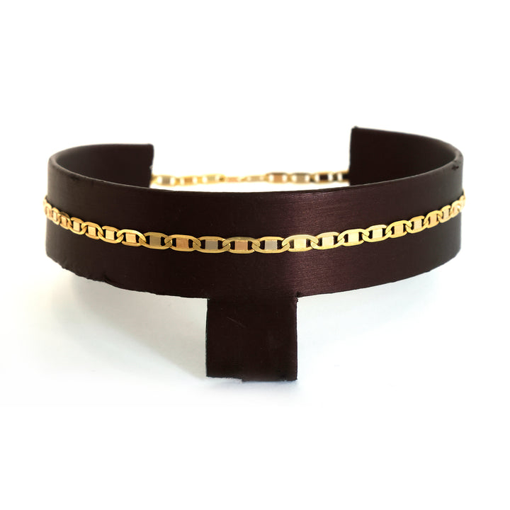 Black leather choker with gold chain detail on a white background