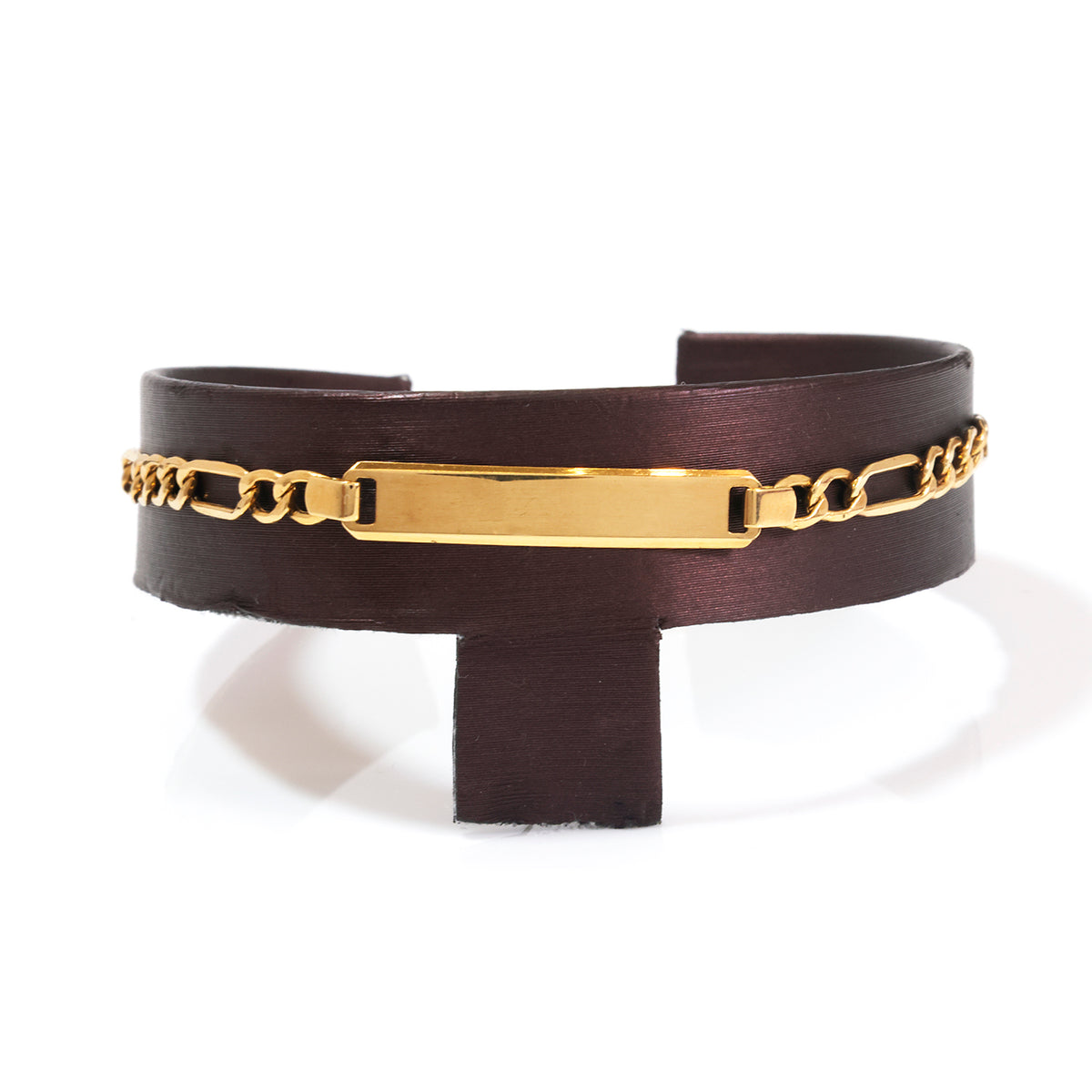 A dark brown leather cuff bracelet with a polished gold-tone ID plate and chain detail, displayed on a white background.