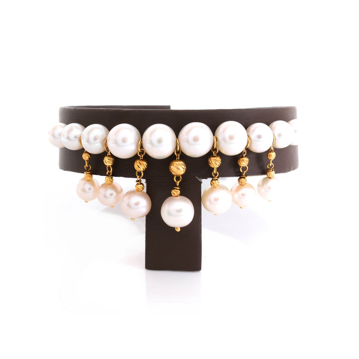 A multi-strand pearl necklace with gold-tone chain links and dangling pearl charms, displayed on a black jewelry stand against a white background.