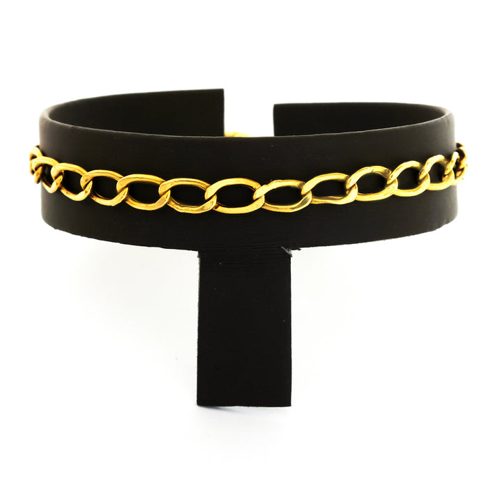 Black choker with gold chain detail on a white background