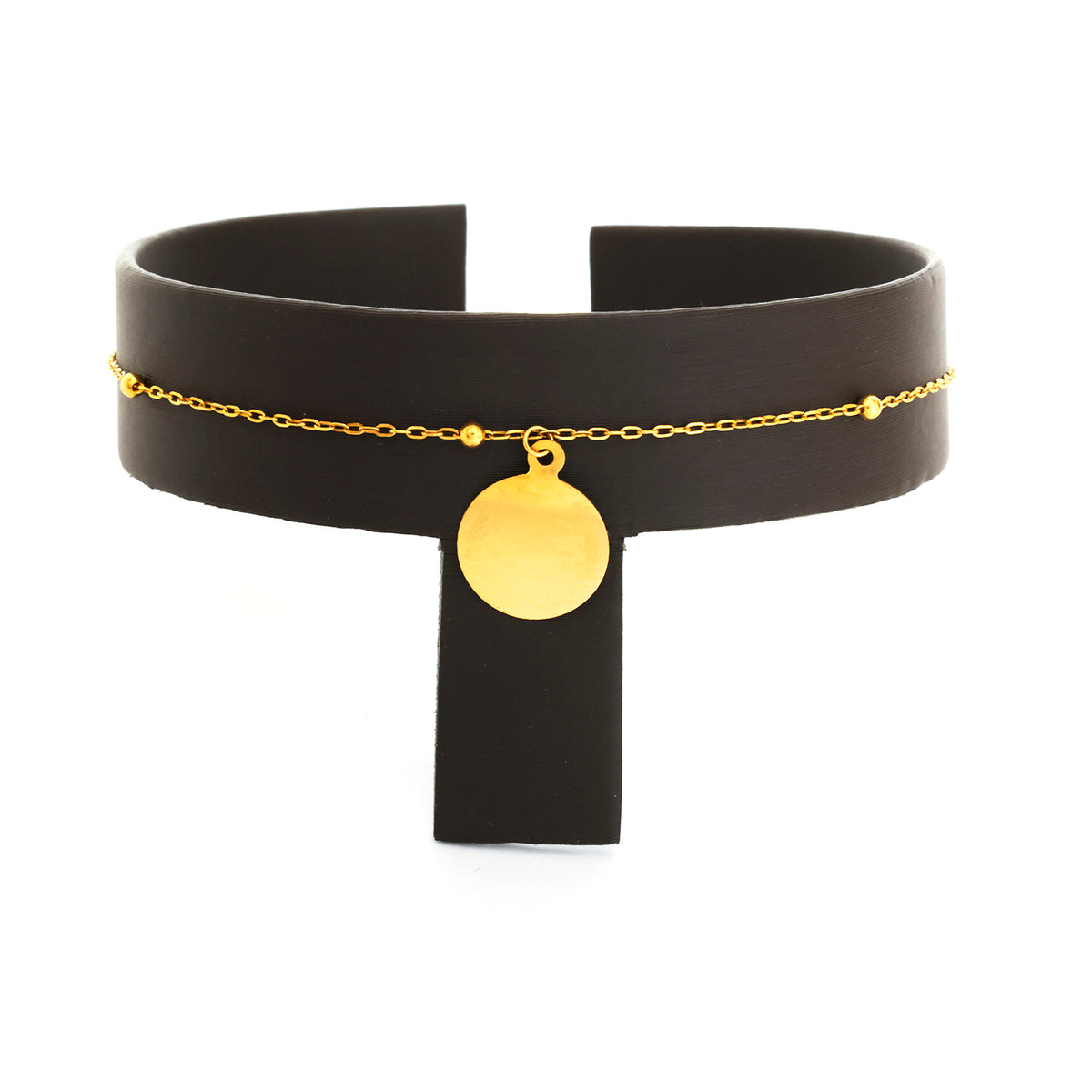 Black choker necklace with gold chain and pendant on a white background