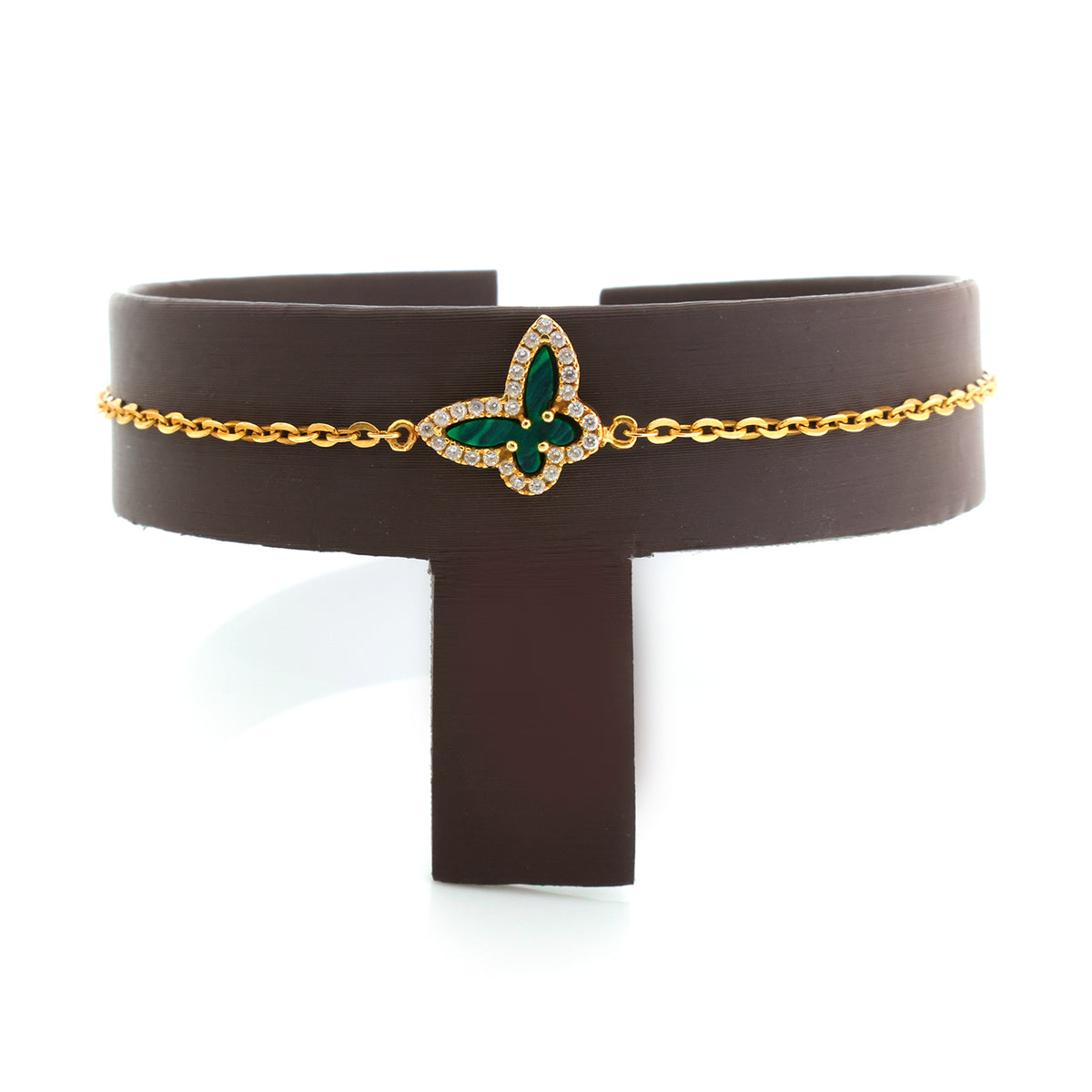 Brown leather belt with gold chain and green gemstone buckle on a white background