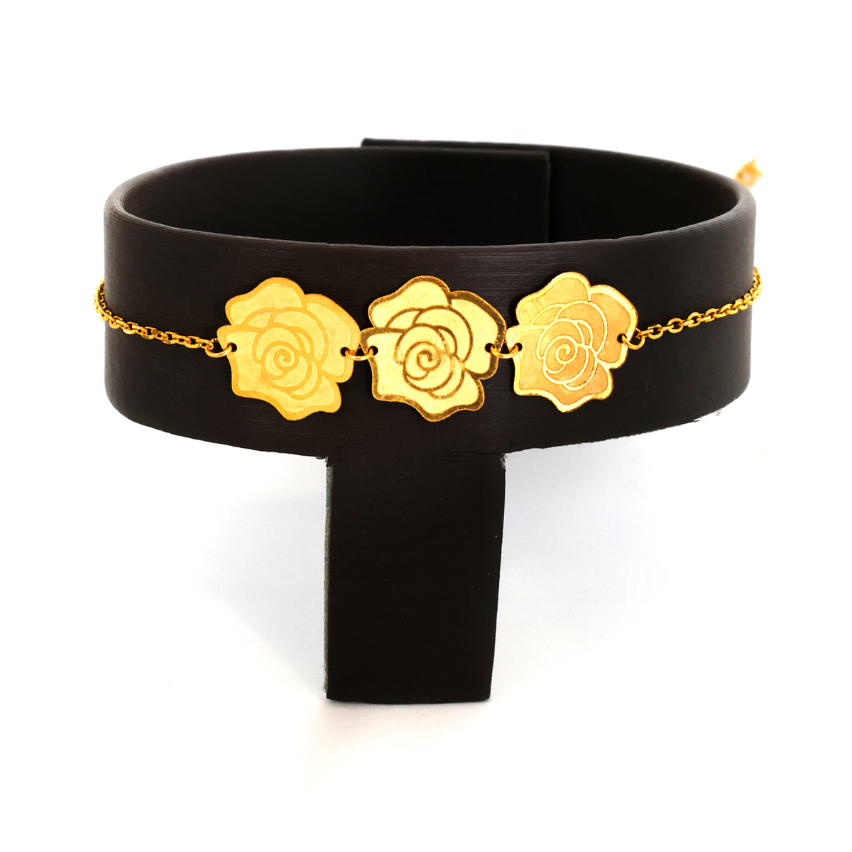 Black choker with gold rose-shaped pendants on a white background