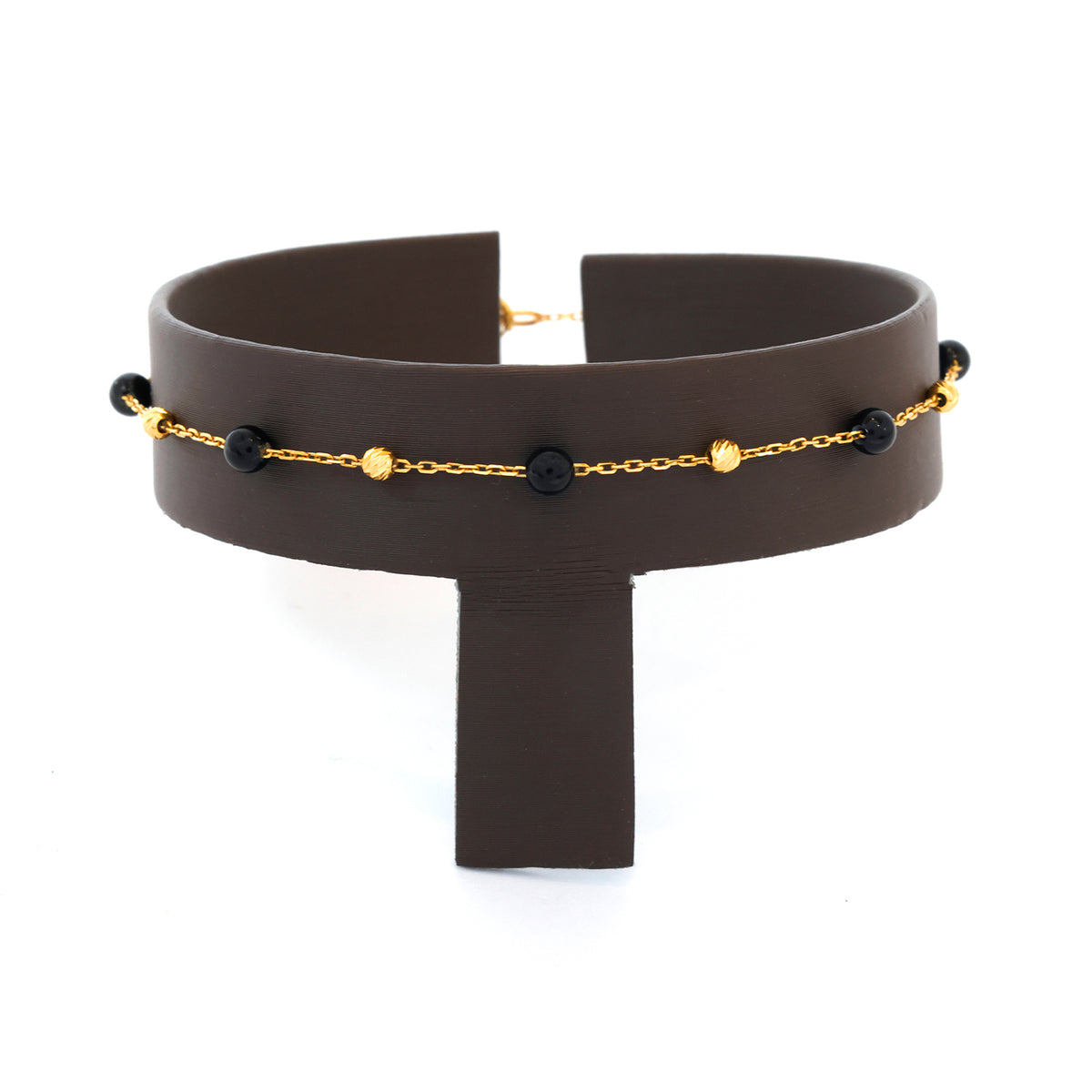 Black choker necklace with gold chain and black beads on a white background