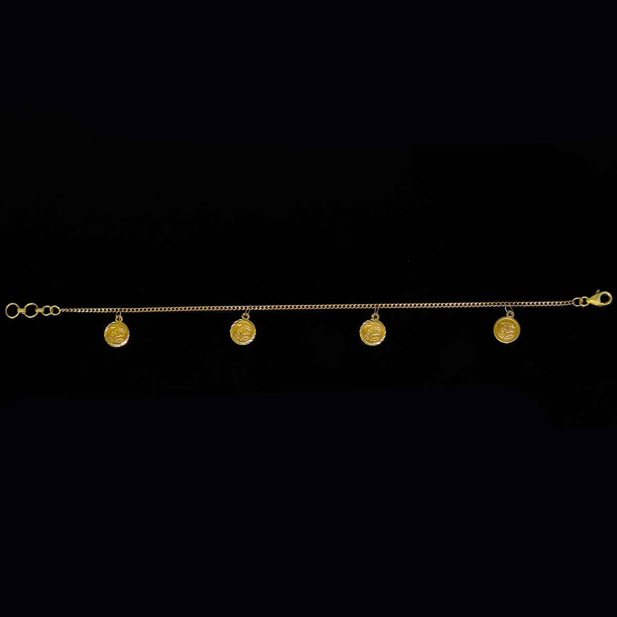 Gold bracelet with five round pendants on a black background