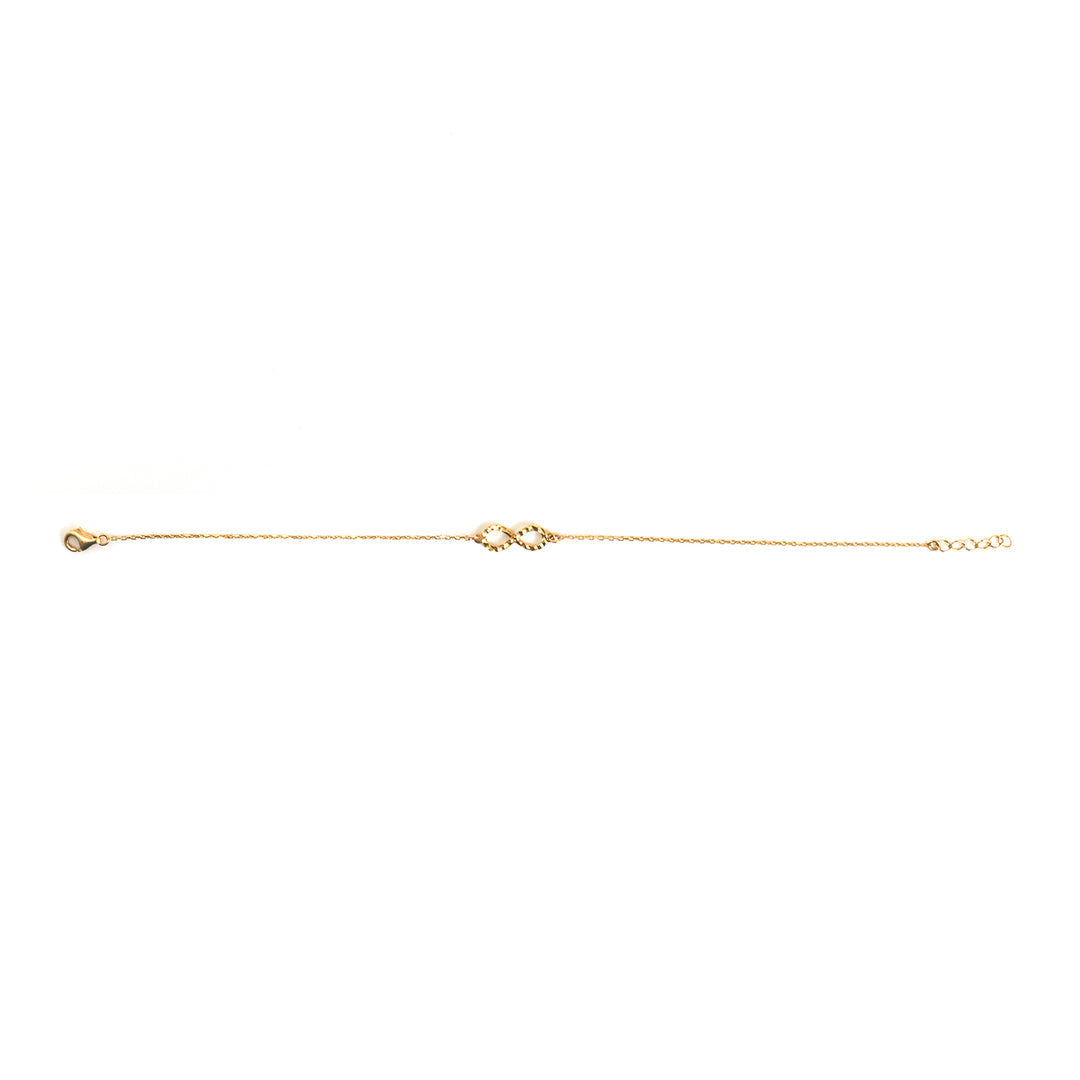 A delicate gold chain bracelet with a small central heart-shaped charm, displayed horizontally on a solid white background.