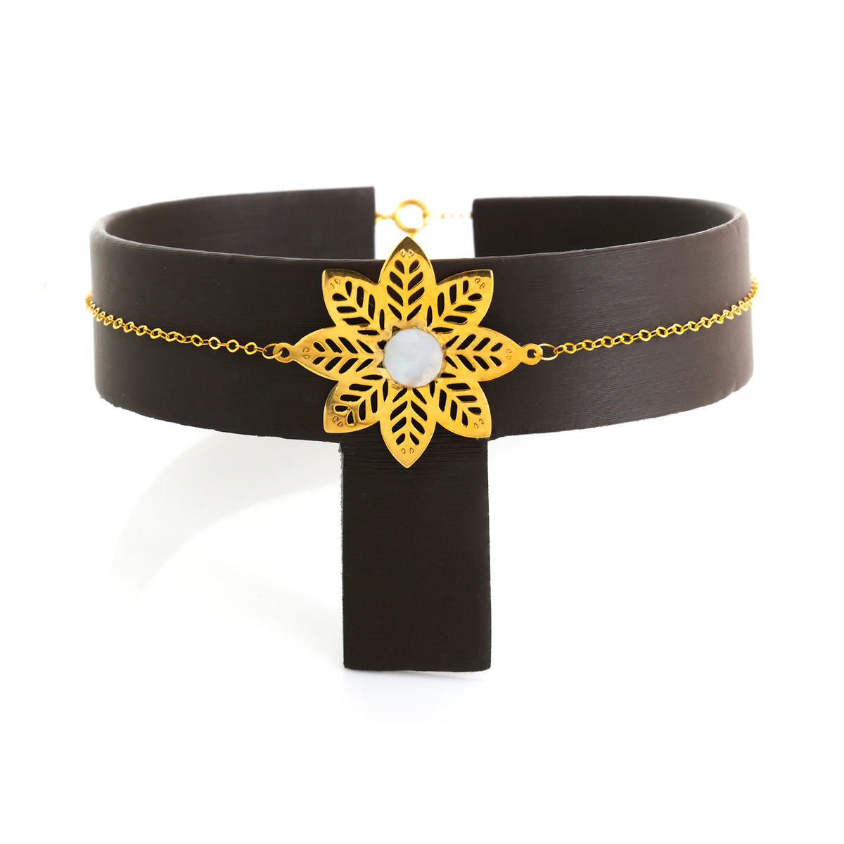 Black choker with gold floral design and central stone on a white background