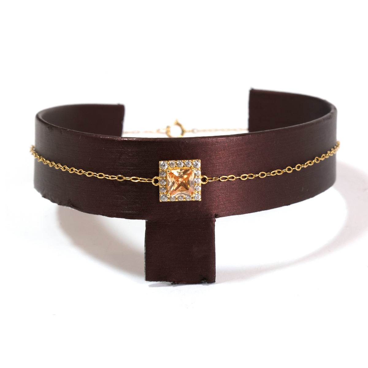 Brown leather choker with gold chain and star-shaped clasp on a white background