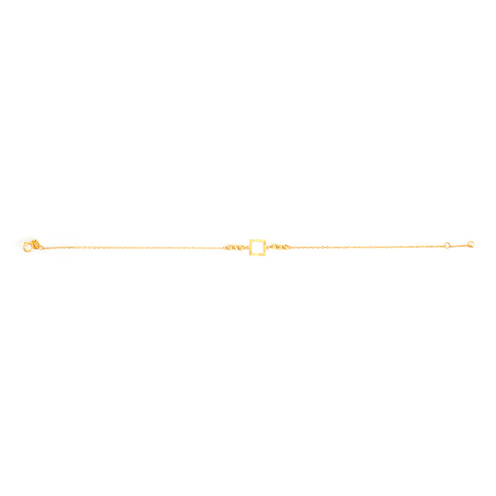 A delicate gold chain bracelet featuring a central open square charm, displayed horizontally against a solid white background.