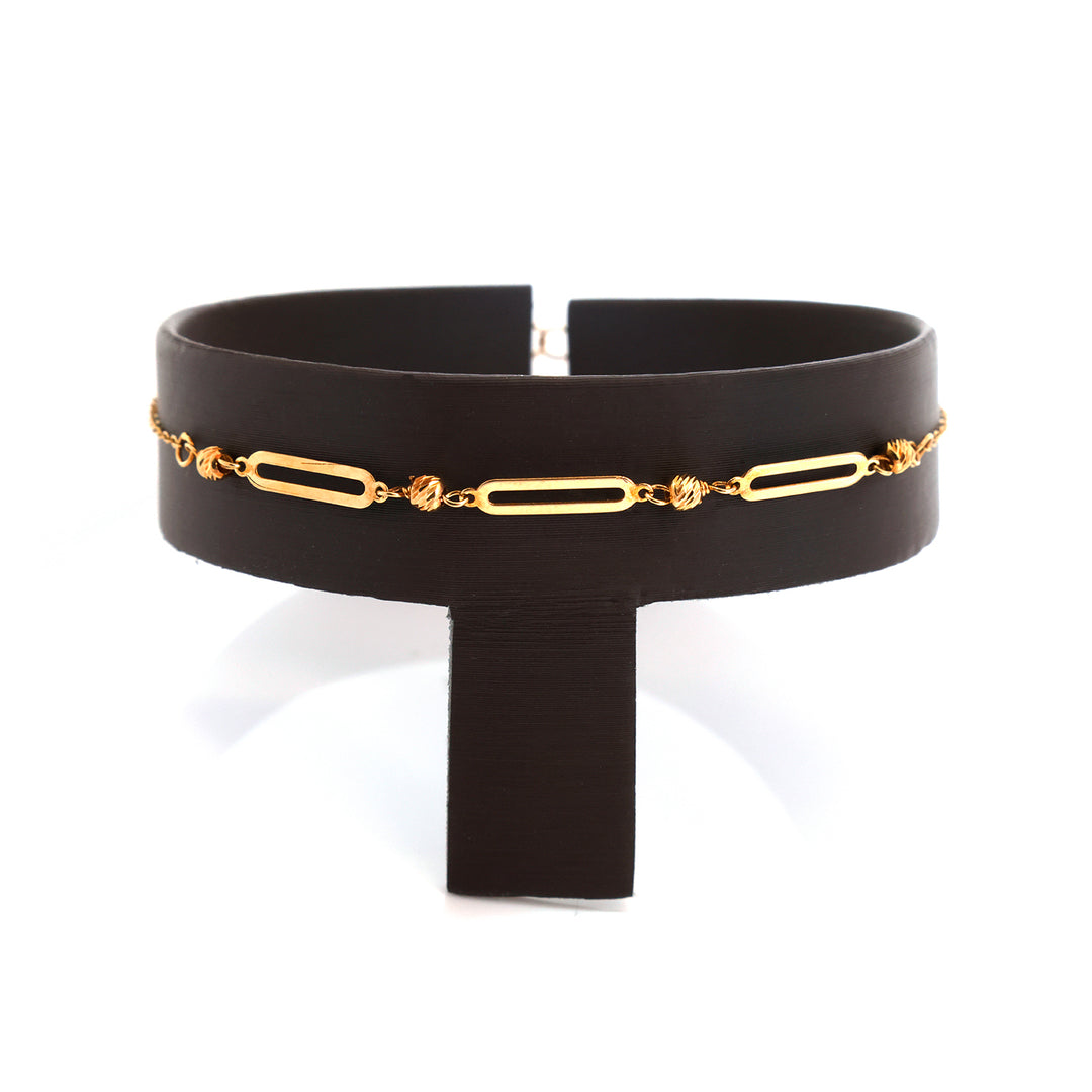 A wide black leather choker bracelet featuring a delicate gold paperclip chain with small gold charms, displayed on a white background.
