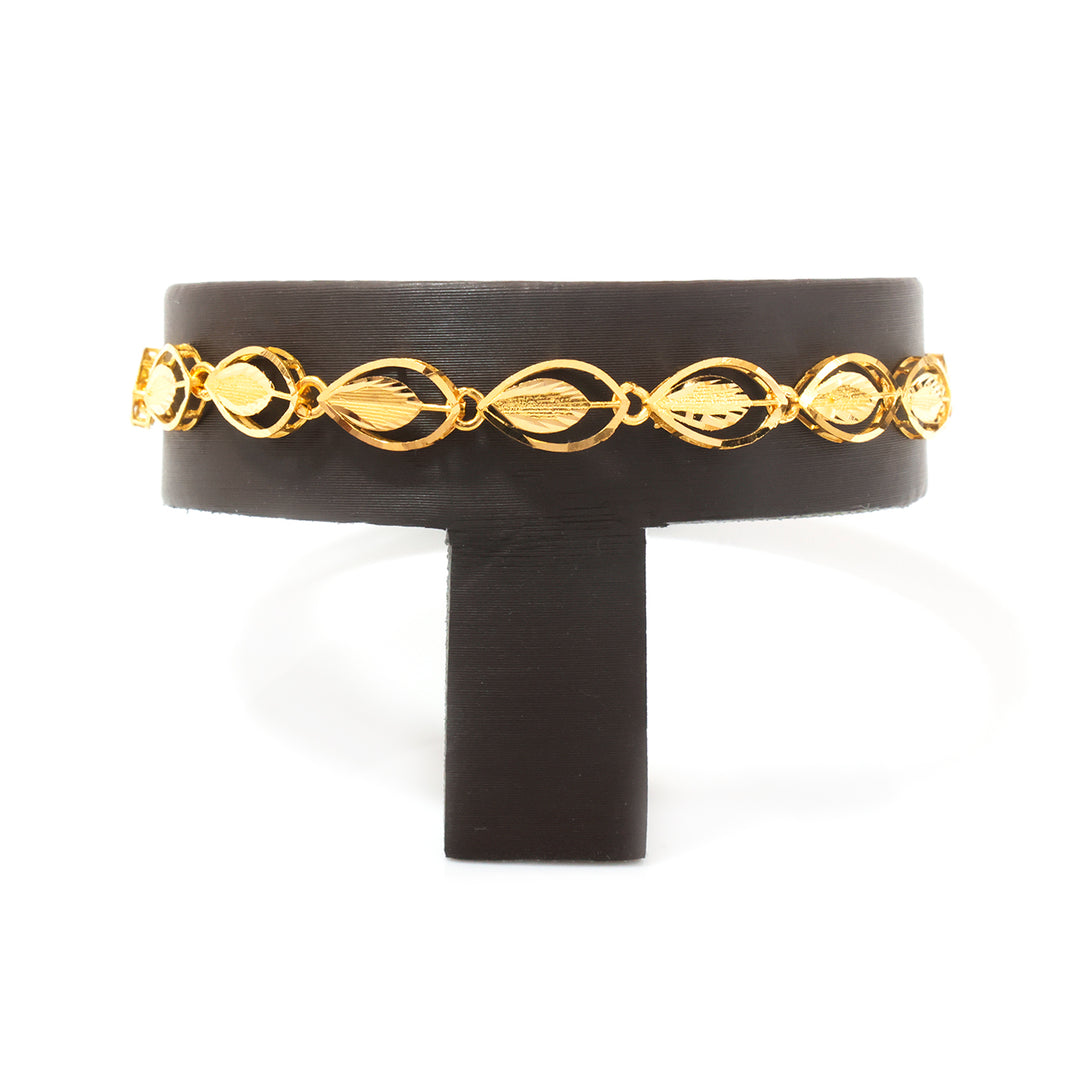 A gold chain bracelet with repeating leaf-shaped links, displayed on a black jewelry stand against a white background.