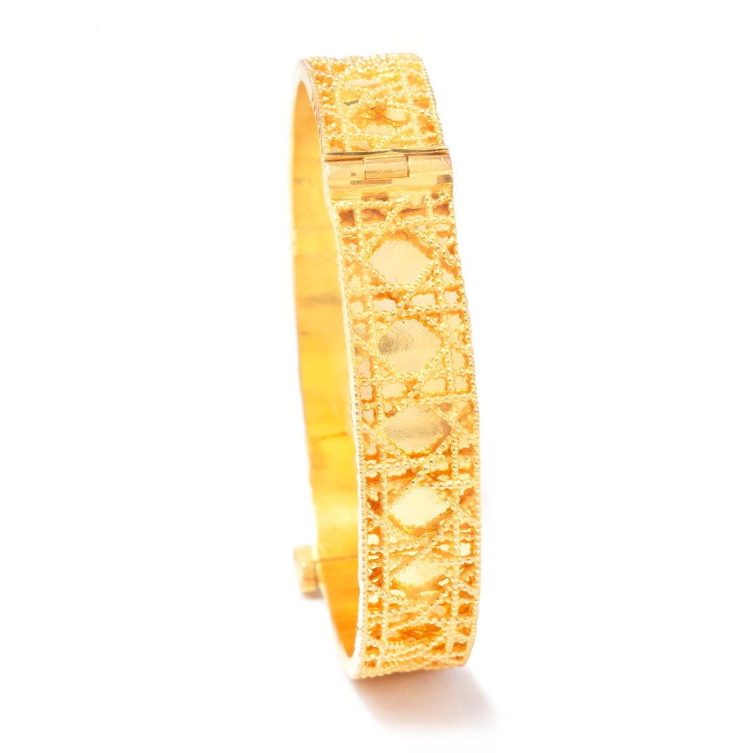 A gold-plated filigree bangle bracelet with a textured geometric pattern, shown on a plain white background.