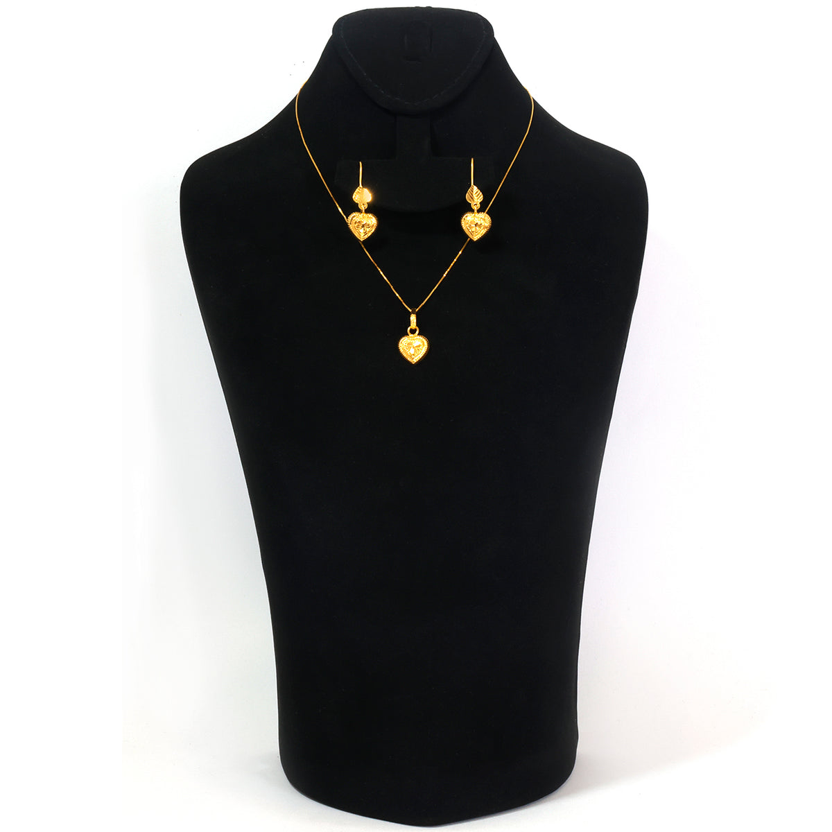 Gold heart pendant necklace and matching drop earrings displayed on a black jewelry bust against a white background.