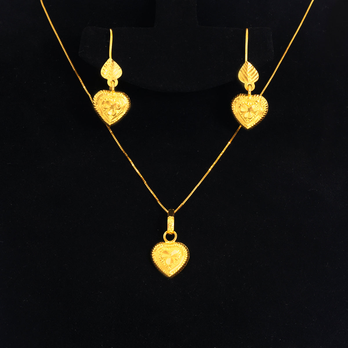 Gold heart pendant necklace and matching drop earrings displayed on a black jewelry stand against a black background.