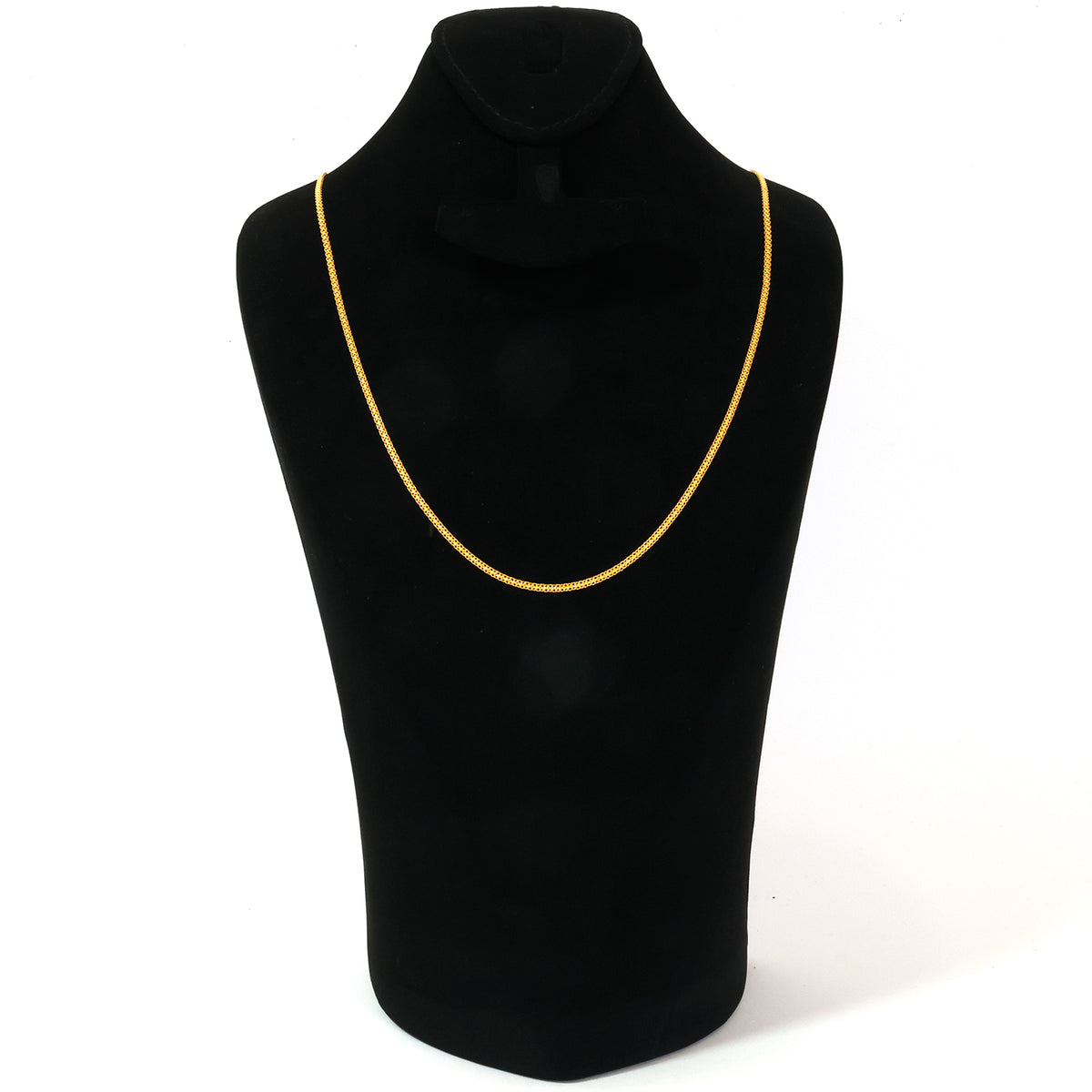 Black mannequin with a gold necklace on a white background
