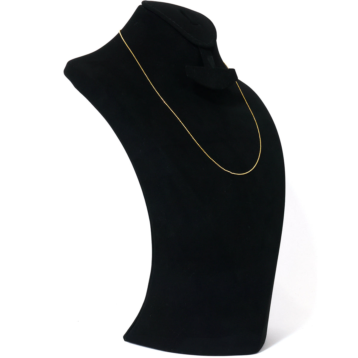 Gold necklace on a black mannequin bust against a white background