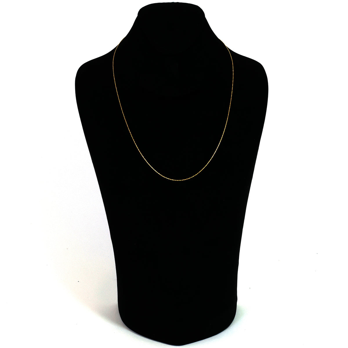 Gold necklace on a black mannequin bust against a white background