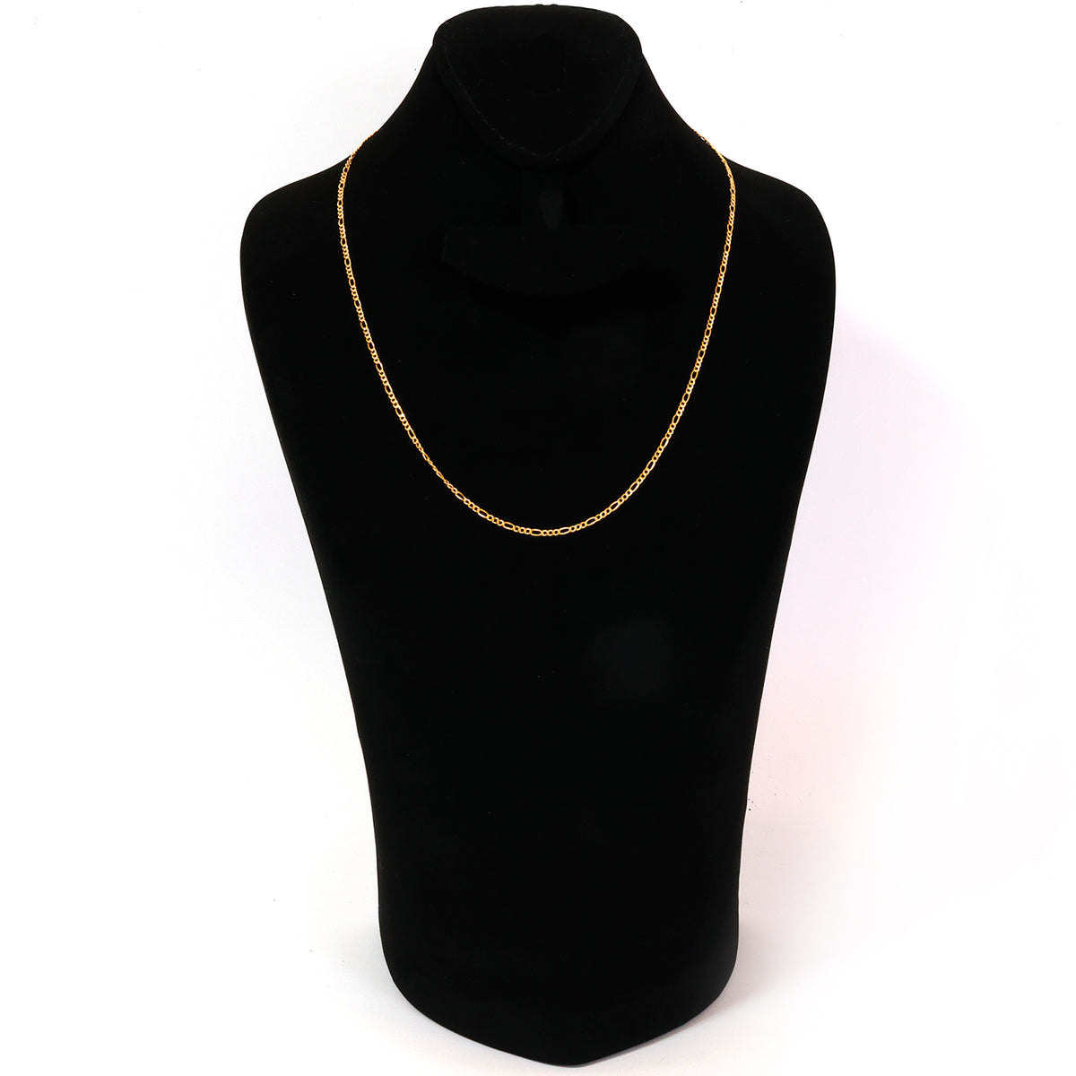 Gold necklace on a black mannequin bust against a white background