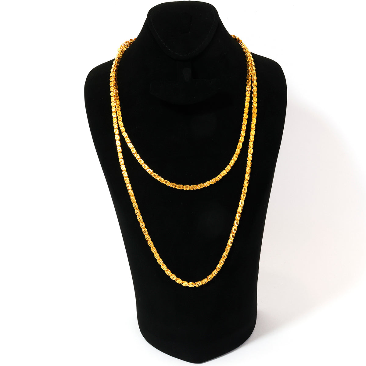 Gold necklace on a black mannequin bust against a white background