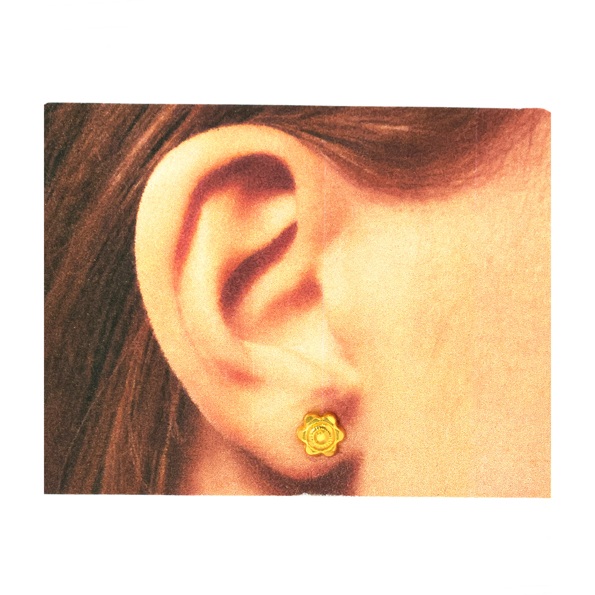 Close-up of an ear wearing a gold earring with a white background