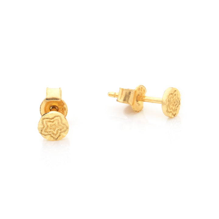 A pair of gold stud earrings with a circular face featuring an engraved star pattern, shown from both front and side angles on a white background.