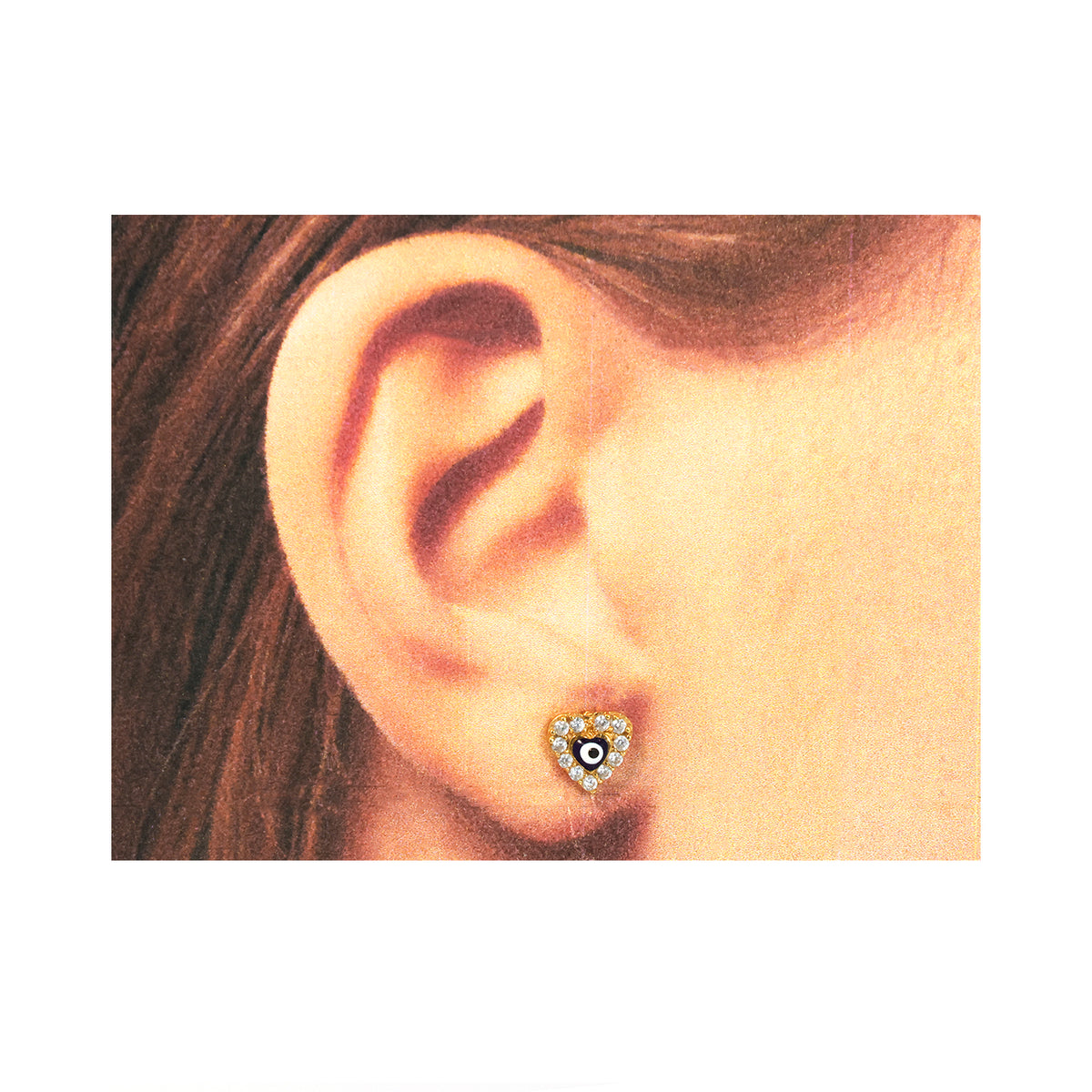 Close-up من ear weaخاتم قلب-shaped قرط مع central gemstone.