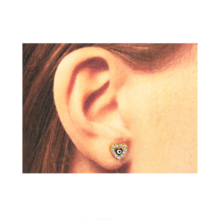 Close-up من ear weaخاتم قلب-shaped قرط مع central gemstone.