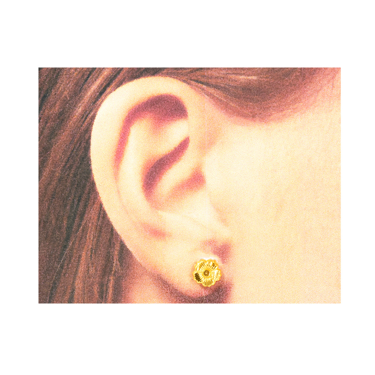 Close-up of an ear wearing a gold earring with hair partially visible.