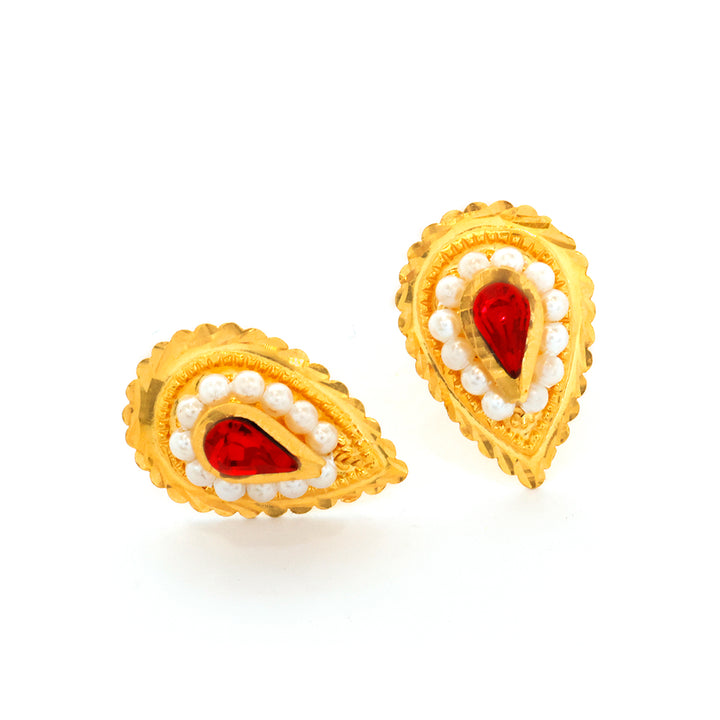 Gold earrings with red gemstones and white beads on a white background