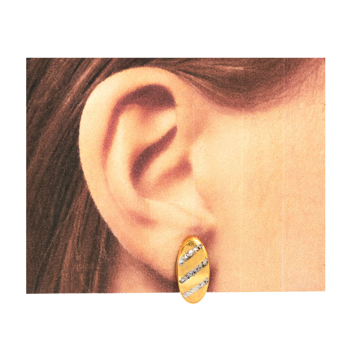 Gold hoop earring worn by a person with brown hair.