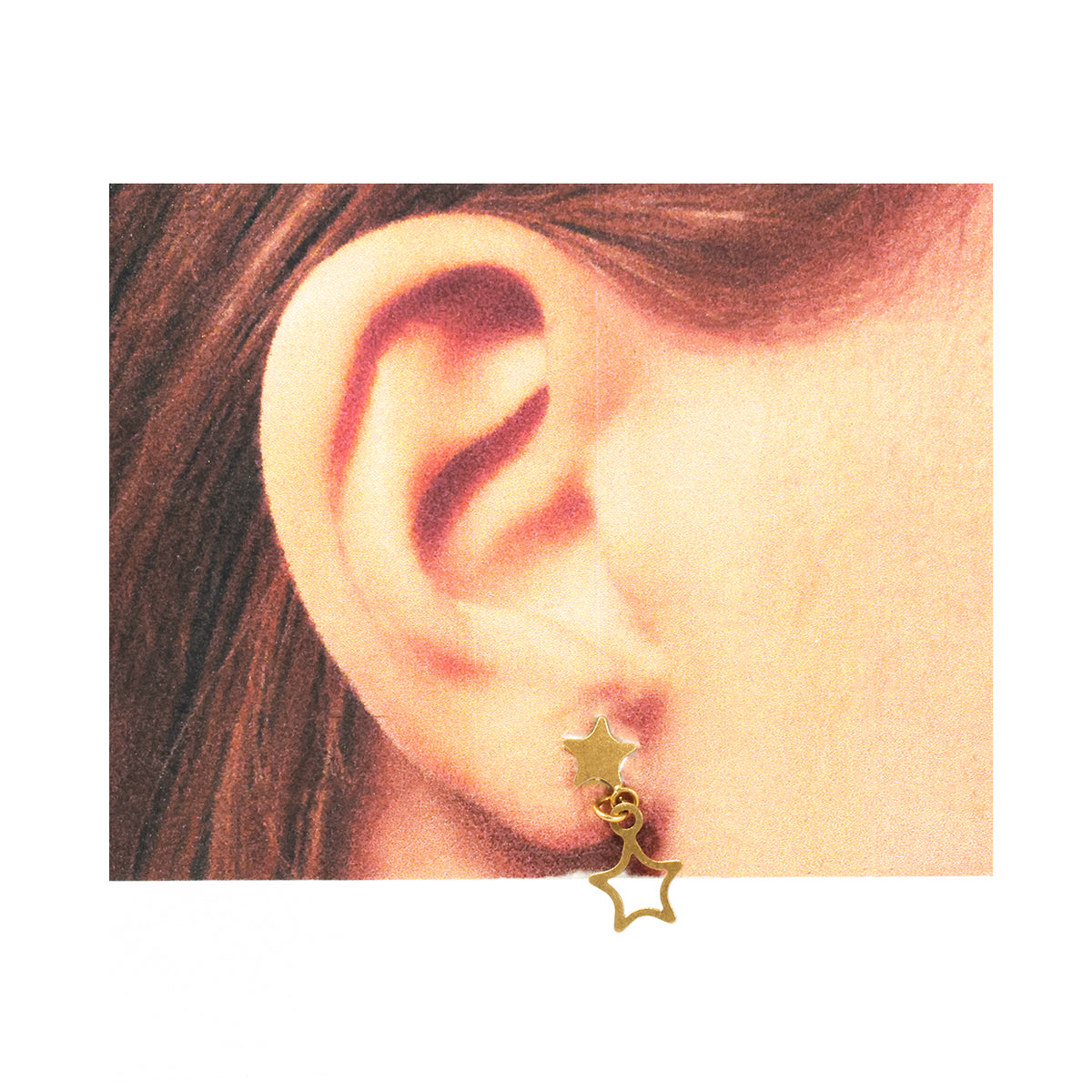 Gold star-shaped earring worn by a person with brown hair.