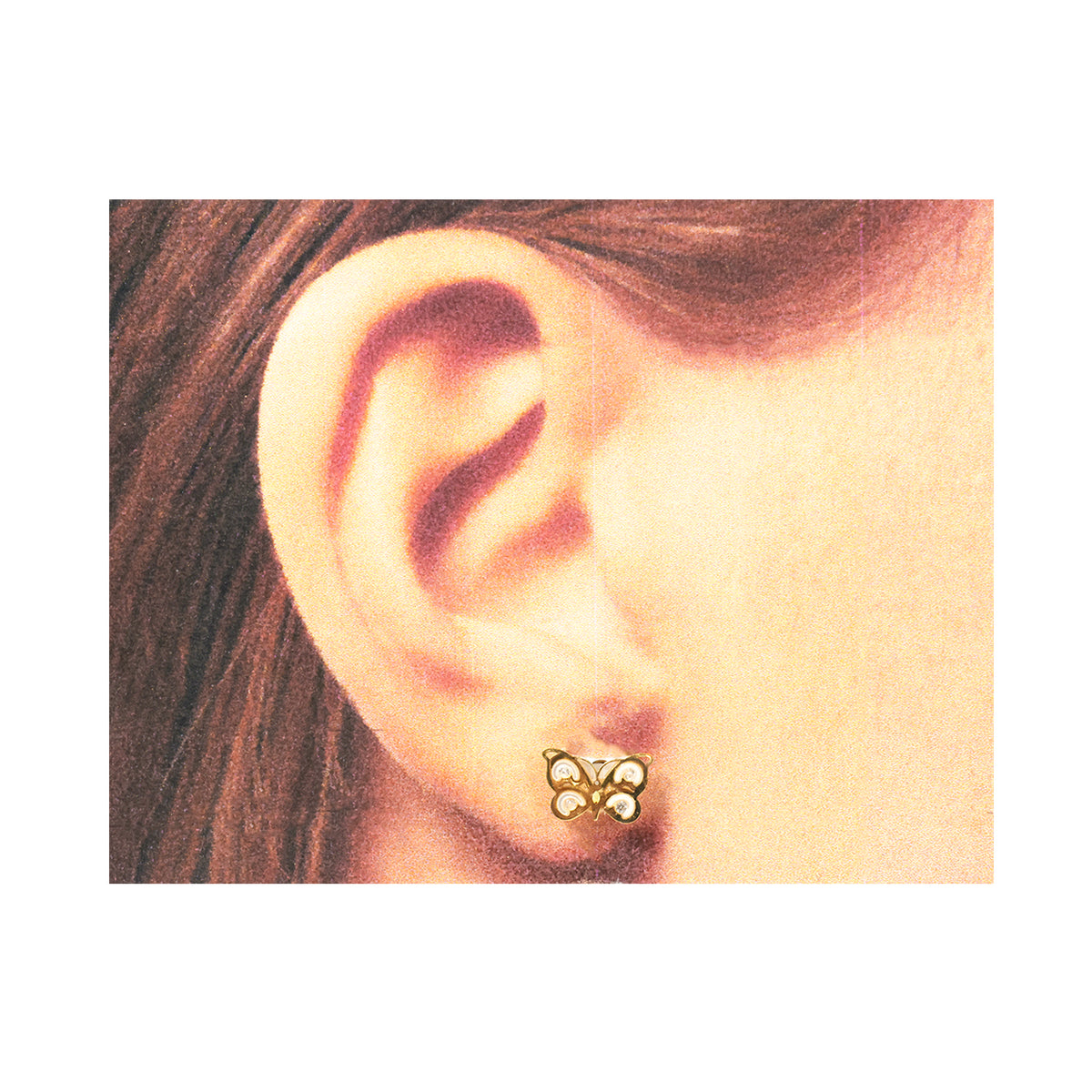 Butterfly-shaped earring worn by a person with brown hair.