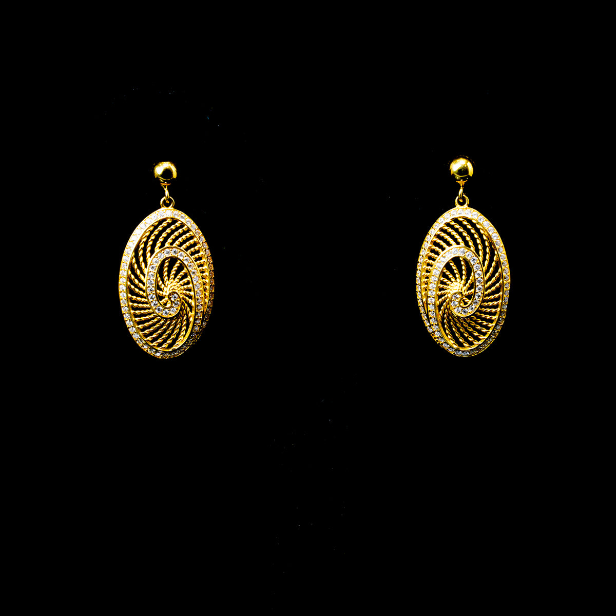 Gold spiral earrings on a black background