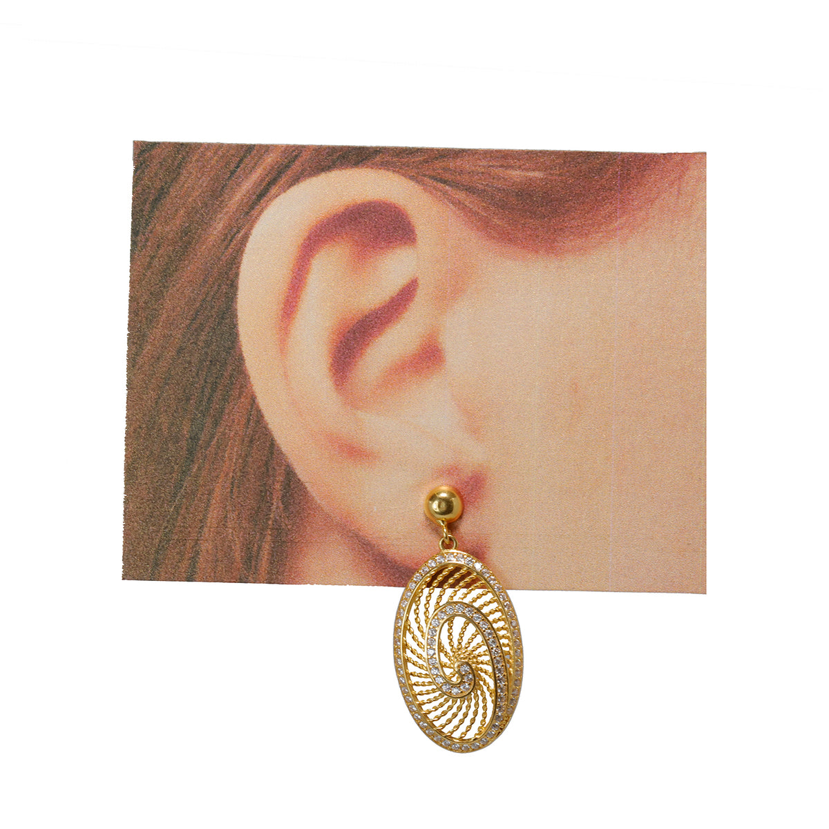 Gold spiral earring worn on an ear with a plain background