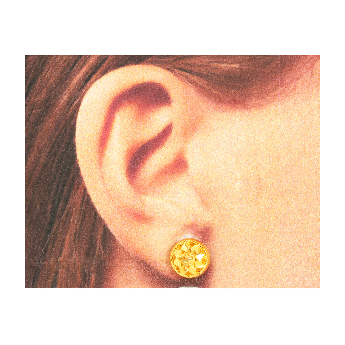 Close-up of an ear wearing a gold earring with a yellow gemstone.