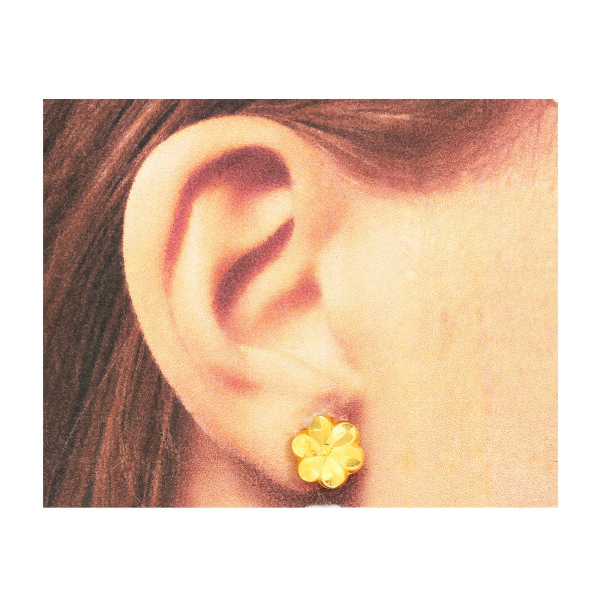 Close-up of an ear wearing a gold flower-shaped earring.