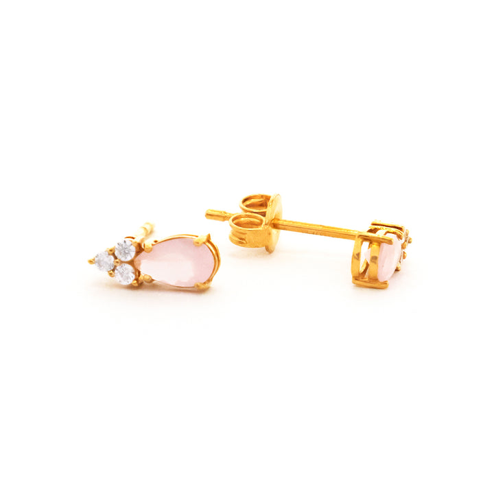 Gold earrings with pink gemstones on a white background