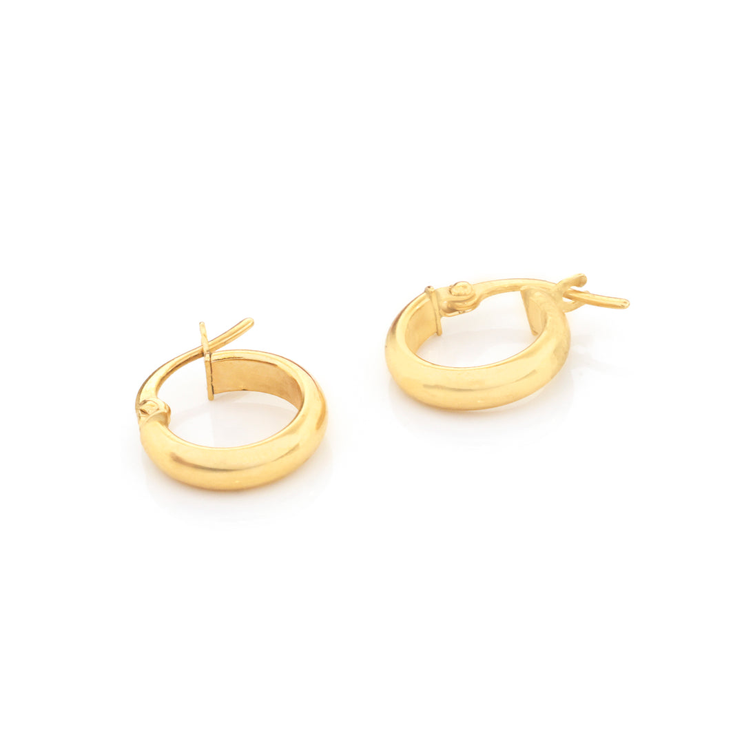 A pair of polished yellow gold hoop earrings with a flat, rounded finish and secure latch backs, displayed on a clean white background.