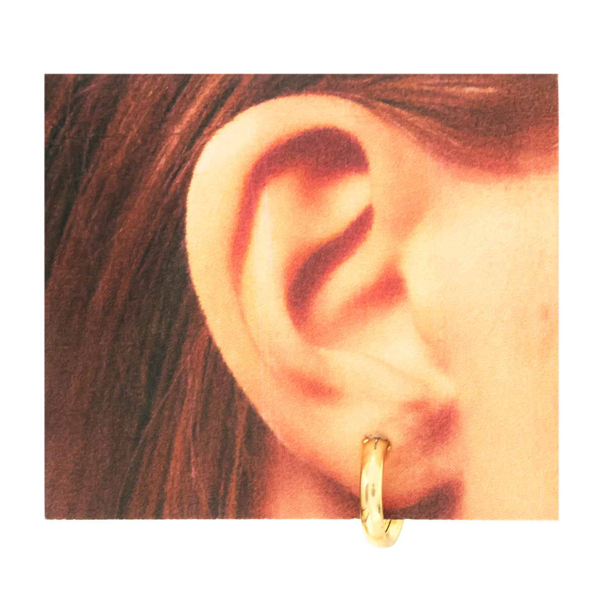 A close-up of a person's ear wearing a small gold hoop earring, shown against a plain white background.