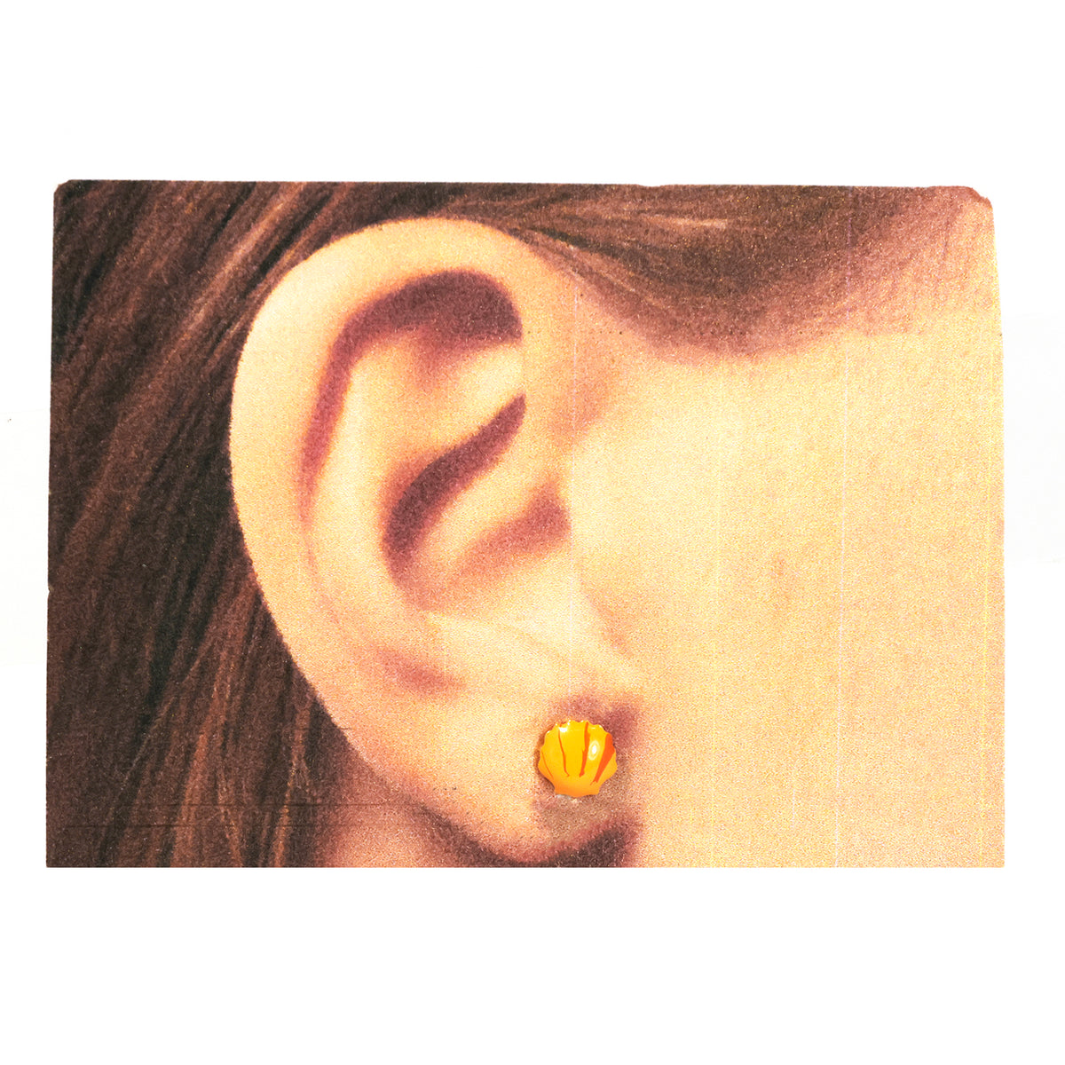 Close-up of an ear wearing a gold earring with a plain background