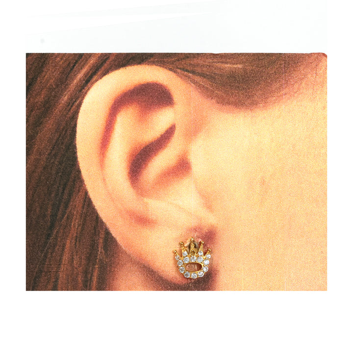 Close-up of an ear wearing a gold and diamond earring.