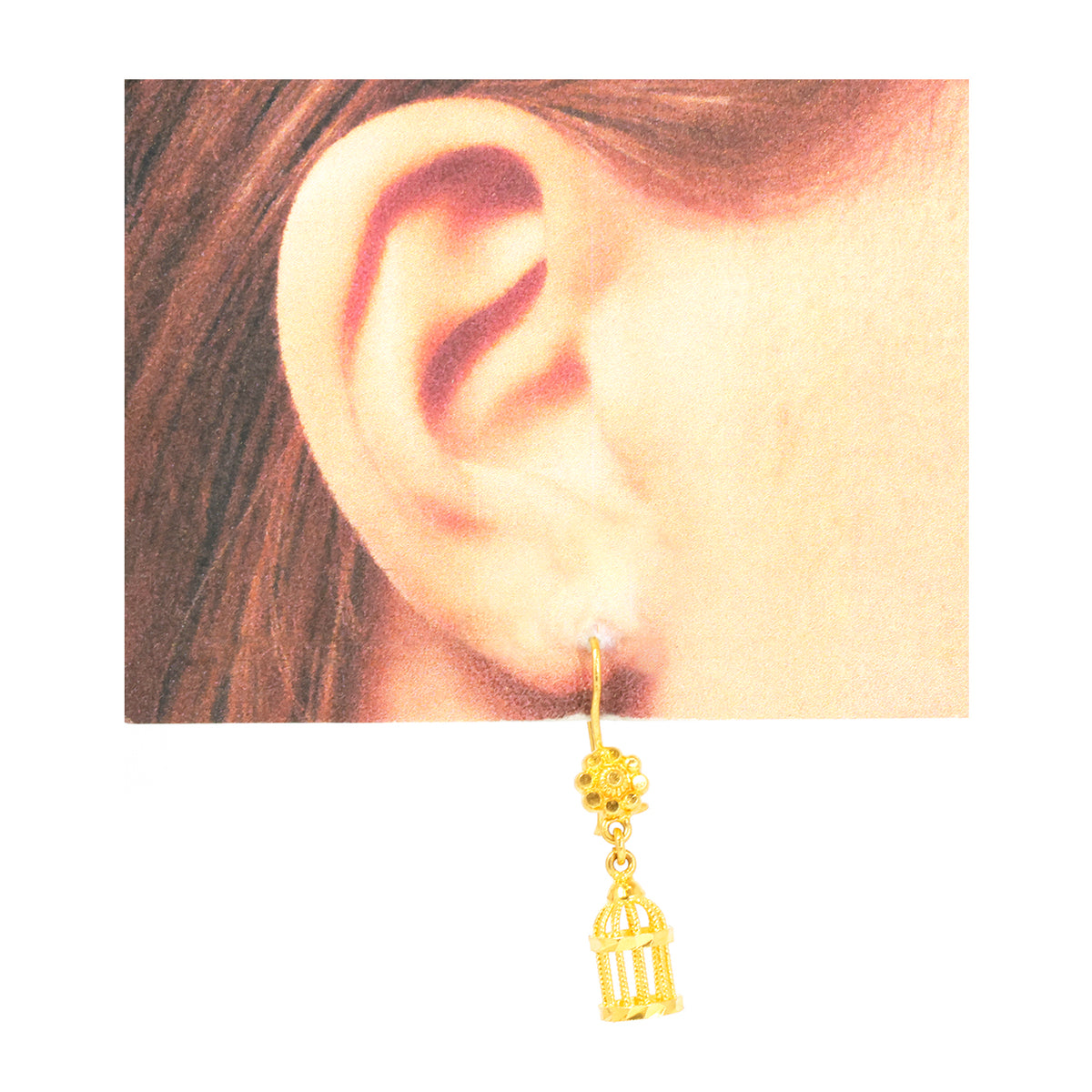 Gold birdcage earring worn on a model's ear