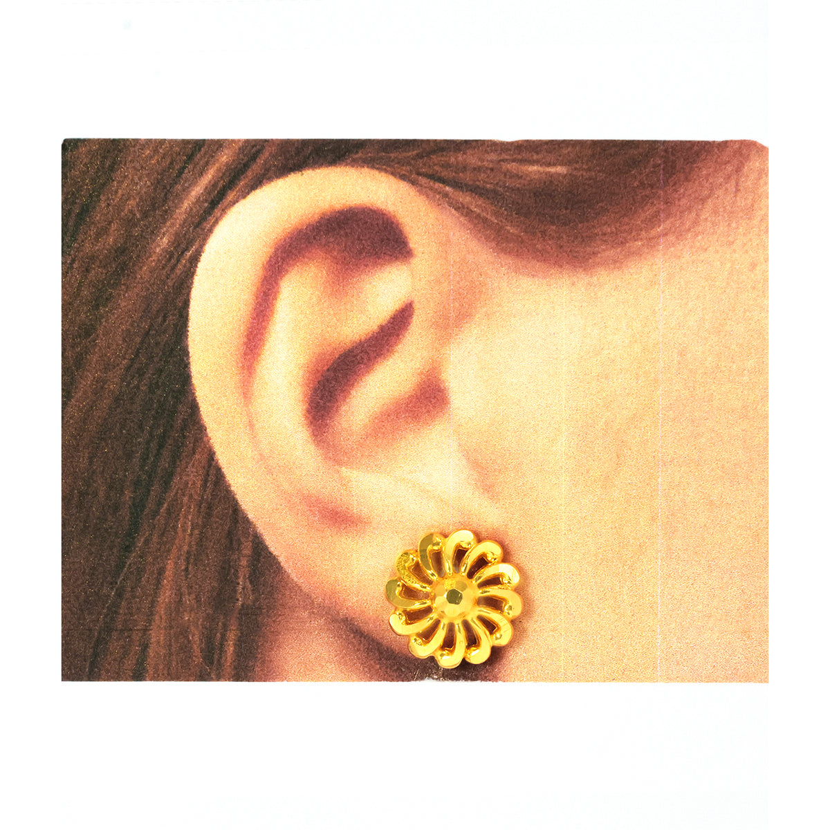 Gold floral earring worn on a model's ear against a white background