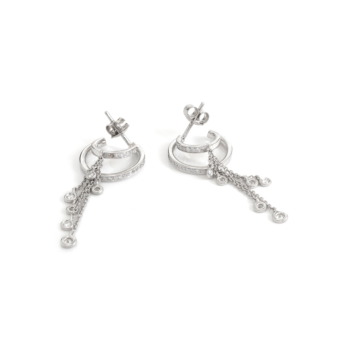 A pair of silver crescent-shaped hoop earrings with dangling chains and small circular charms, shown on a plain white background.
